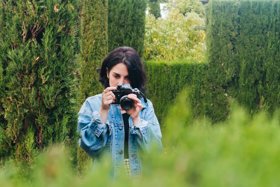 portrait-of-young-female-photographer-taking-picture-of-nature-with-camera_23-2148222009